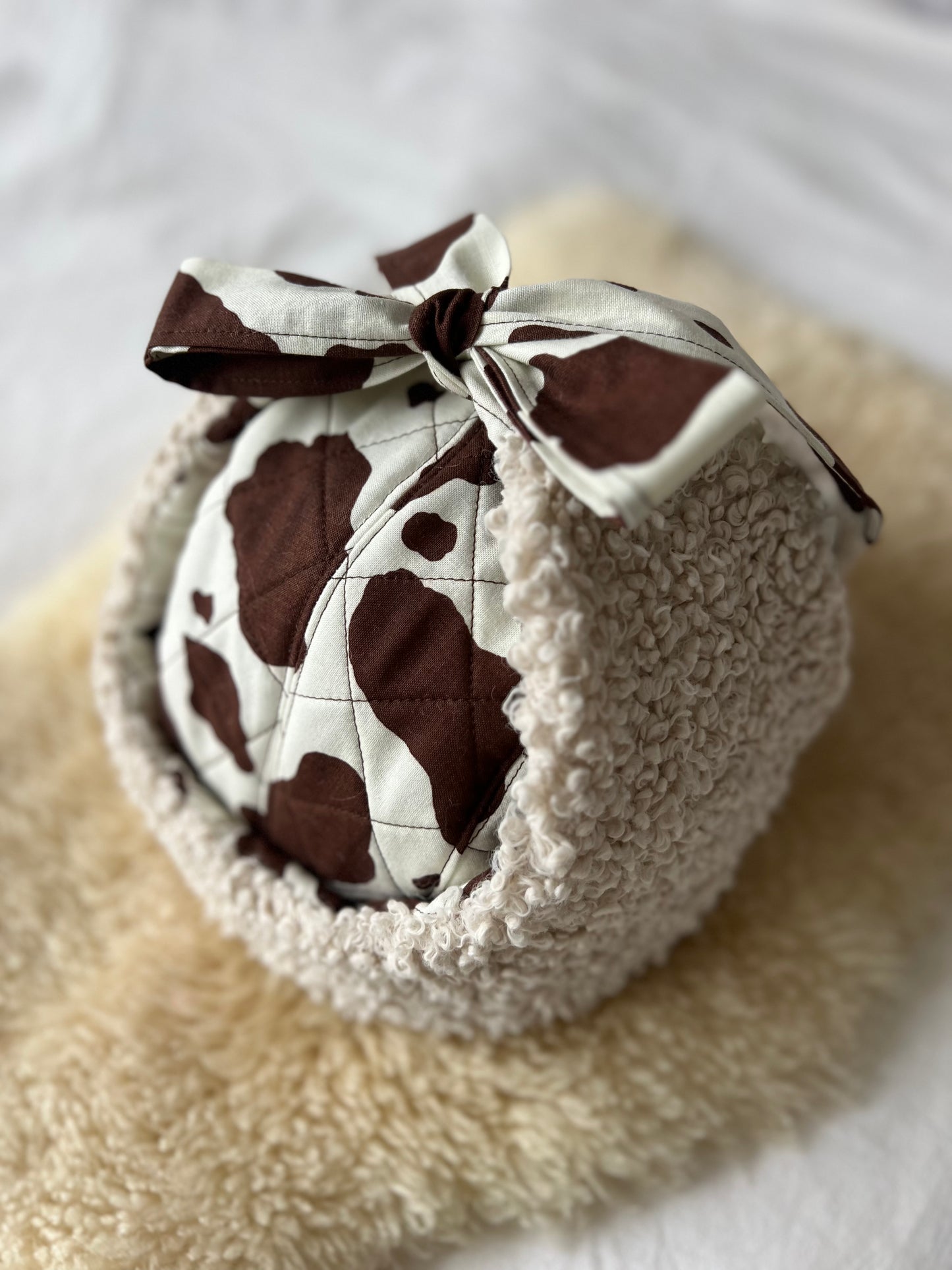 Quilted brown cow and sherpa trapper hat